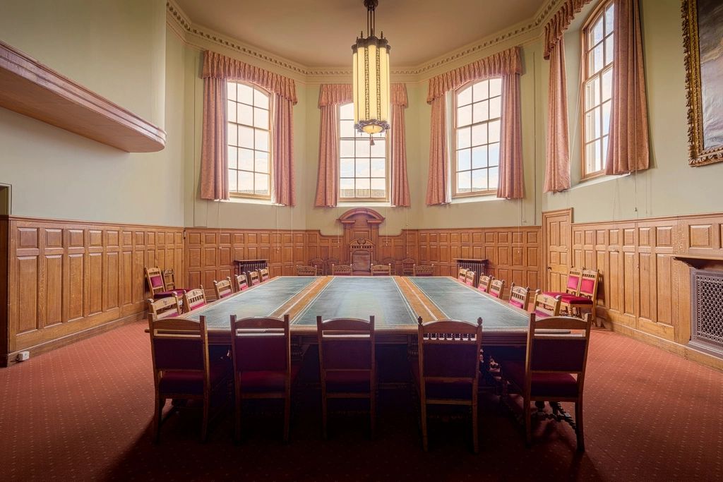A meeting room with a long table and chairs