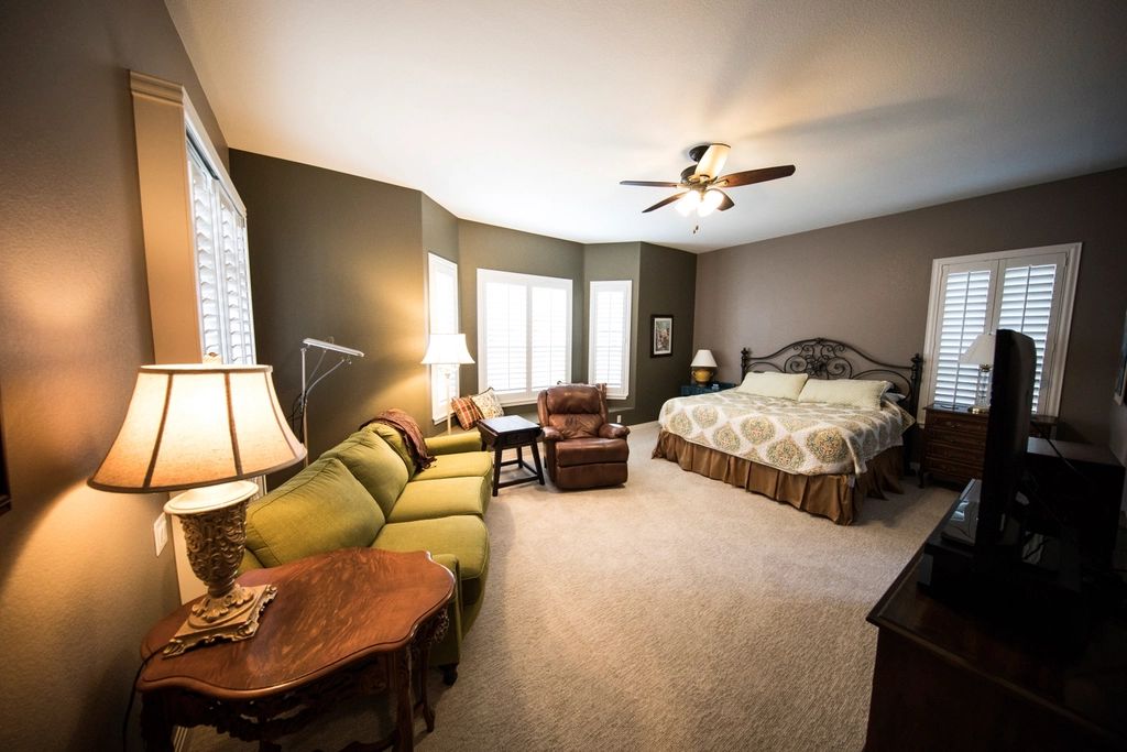 A guest room with a large bed and soft lighting